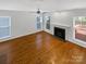 Spacious living room featuring hardwood floors, a fireplace, and natural light from multiple windows at 3114 Parker Green Trl, Charlotte, NC 28269
