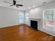 Spacious living room with fireplace, hardwood floors, large windows, and ceiling fan at 3114 Parker Green Trl, Charlotte, NC 28269