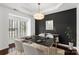 Elegant dining room with a modern black table, stylish chandelier, and black accent wall at 3214 Park South Station Blvd, Charlotte, NC 28210