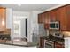 Modern kitchen with stainless steel appliances, granite countertops, and brown cabinets at 3214 Park South Station Blvd, Charlotte, NC 28210