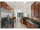 Modern kitchen featuring stainless steel appliances, granite countertops, wooden cabinets, and a view to the dining room at 3214 Park South Station Blvd, Charlotte, NC 28210