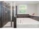 Bathroom featuring shower and tub with tile surround and window at 3248 Park South Station Blvd, Charlotte, NC 28210