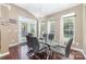 Modern dining room featuring dark hardwood floors, a glass table, and access to the backyard at 3248 Park South Station Blvd, Charlotte, NC 28210
