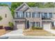 Charming brick townhome featuring a one car garage, blue shutters, and landscaped front yard at 3248 Park South Station Blvd, Charlotte, NC 28210