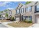 A well-maintained brick townhome showcasing dark shutters, a garage, and tidy landscaping at 3248 Park South Station Blvd, Charlotte, NC 28210
