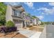 View of an attractive brick townhome featuring a driveway, one-car garage, and manicured lawn at 3248 Park South Station Blvd, Charlotte, NC 28210