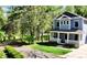 A view of the beautiful blue exterior, manicured lawn and wooded scenery at 420 Solomon St, Charlotte, NC 28216