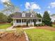 Charming home featuring a welcoming front porch, lush lawn, and beautiful landscaping at 4222 Mt Gallant Rd, Rock Hill, SC 29732