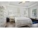 Bright bedroom featuring white walls, tray ceiling, and large windows with a modern ceiling fan at 562 Amalfi Dr, Davidson, NC 28036