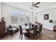 Sunlit dining room with a glass-top table, modern chairs, wood floors, and large windows offering a neighborhood view at 562 Amalfi Dr, Davidson, NC 28036