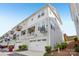 Charming townhome showcasing a white garage door, a cute balcony, and gray siding under a clear blue sky at 562 Amalfi Dr, Davidson, NC 28036