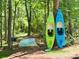 Two kayaks and a canoe sit ready for summer fun amongst the trees near the water at 562 Amalfi Dr, Davidson, NC 28036