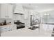 Close-up of a modern kitchen, showing stainless steel appliances, white countertops, and a view into the adjacent living space at 562 Amalfi Dr, Davidson, NC 28036