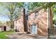 Expansive backyard of a brick home featuring mature trees and a concrete patio at 6001 Plaza Ln, Charlotte, NC 28215