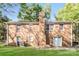 The backyard features a well-maintained lawn, a brick house facade, and is framed by mature trees and sky at 6001 Plaza Ln, Charlotte, NC 28215