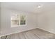 Bedroom with neutral gray walls, updated flooring, a light fixture, and a large window providing plenty of light at 6001 Plaza Ln, Charlotte, NC 28215