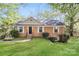 Charming brick home featuring a well-manicured lawn and traditional architectural details at 6001 Plaza Ln, Charlotte, NC 28215
