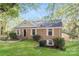 Charming brick home featuring a well-manicured lawn and traditional architectural details at 6001 Plaza Ln, Charlotte, NC 28215