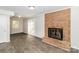Bright living room with brick fireplace, gray walls, modern floors, and access to the backyard via sliding glass doors at 6001 Plaza Ln, Charlotte, NC 28215