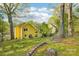 Backyard view of yellow home with green landscaping and mature trees on a sunny day at 6005 Lanai Ln, Tega Cay, SC 29708