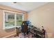 Bedroom with neutral-colored walls, a large window overlooking the wooded backyard, and space for a work-from-home setup at 6005 Lanai Ln, Tega Cay, SC 29708