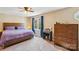 Well-lit bedroom with a wooden bed frame, makeup vanity, chest of drawers, and a large window at 6005 Lanai Ln, Tega Cay, SC 29708