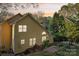 Back exterior view of yellow siding house with wooden deck, landscaping, and sunset sky at 6005 Lanai Ln, Tega Cay, SC 29708
