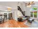 Living room with hardwood floors, connecting kitchen, and stairway to upper level at 6005 Lanai Ln, Tega Cay, SC 29708
