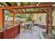 Backyard stone fireplace on patio with dining table under pergola and string lights at 6005 Lanai Ln, Tega Cay, SC 29708