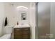 Modern bathroom with white vanity, wood cabinets, and glass-enclosed shower at 6921 Thermal Rd, Charlotte, NC 28211