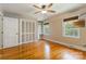Bedroom featuring a ceiling fan, two windows, wood floors, and a closet with built-in shelves at 6921 Thermal Rd, Charlotte, NC 28211