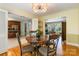 Inviting dining room featuring hardwood floors, stylish lighting, and seamless flow to the kitchen at 6921 Thermal Rd, Charlotte, NC 28211