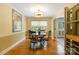 Sunny dining room with hardwood floors, large window, and stylish light fixture at 6921 Thermal Rd, Charlotte, NC 28211