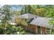 A brick and siding exterior with a deck above, surrounded by lush landscaping, perfect for outdoor living at 6921 Thermal Rd, Charlotte, NC 28211