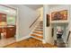 Hallway featuring hardwood floors, staircase, and entryway to kitchen at 6921 Thermal Rd, Charlotte, NC 28211