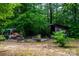 Secluded backyard oasis with a firepit, swing, storage shed, and lush greenery, offering a peaceful retreat at 7050 Forney Hill Rd, Denver, NC 28037