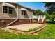 Backyard featuring a brick-lined patio, wooden deck with stairs, and well-manicured landscaping, ideal for outdoor living at 7050 Forney Hill Rd, Denver, NC 28037