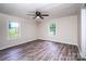 Well lit bedroom with two windows, ceiling fan, and light gray vinyl flooring at 7050 Forney Hill Rd, Denver, NC 28037
