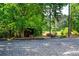 Outdoor firepit area with gravel, a wood shed, and surrounding trees, creating a cozy and private setting at 7050 Forney Hill Rd, Denver, NC 28037