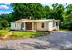 Charming single-story home with an inviting front porch, American flag, and gravel driveway at 7050 Forney Hill Rd, Denver, NC 28037