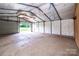 Spacious garage/workshop featuring a roll up door, concrete flooring and white walls at 7050 Forney Hill Rd, Denver, NC 28037