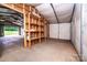 Spacious garage featuring concrete flooring and some built-in wood shelving at 7050 Forney Hill Rd, Denver, NC 28037
