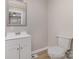 This bathroom offers a toilet, a vanity and mirror, along with modern vinyl floors at 706 Lowell Ave, Lowell, NC 28098