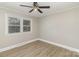 Bright bedroom with light walls, wood-look flooring, and ample natural light from the large window at 706 Lowell Ave, Lowell, NC 28098