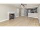 Inviting living room featuring wood-look floors, a cozy fireplace, and an open layout leading to the kitchen at 706 Lowell Ave, Lowell, NC 28098
