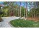 A backyard includes a stone paver patio, lawn, and wooded area with mature trees at 9069 Blue Ridge Dr, Indian Land, SC 29707