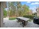 A backyard features a stone paver patio and table with seating in a wooded setting at 9069 Blue Ridge Dr, Indian Land, SC 29707