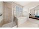 Bathroom with glass enclosed shower, soaking tub and view to main bedroom at 9069 Blue Ridge Dr, Indian Land, SC 29707