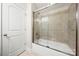 Clean bathroom showcases a bathtub with glass doors and white cabinets at 9069 Blue Ridge Dr, Indian Land, SC 29707