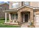 Inviting front porch with stone archway, stylish seating, and tasteful landscaping at 9069 Blue Ridge Dr, Indian Land, SC 29707